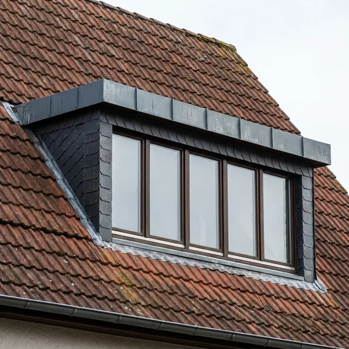 Schleppgaube mit einer einzigen flach geneigten Dachfläche und breitem Fensterband